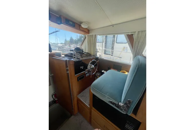 Slide: The Image of 1974 Tollycraft 37 Sedan interior helm with steering wheel and blue captain's chair. - 24