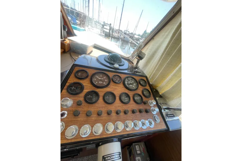 Slide: The Image of 1974 Tollycraft 37 Sedan dashboard with gauges and controls, docked at marina. - 27