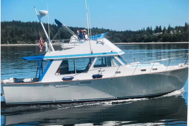 Slide: The Image of 1974 Tollycraft 37 Sedan cruising on calm waters with scenic forest backdrop. - 3