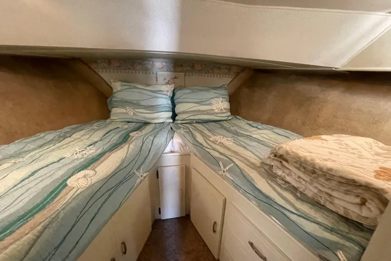 Slide: The Image of 1974 Tollycraft 37 Sedan cabin with twin beds and nautical-themed bedding. - 34