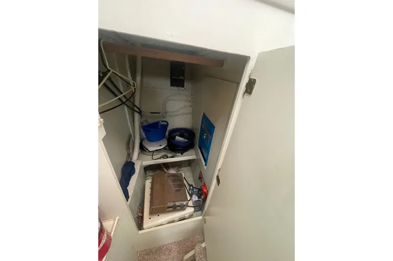 Slide: The Image of Storage compartment inside a 1974 Tollycraft 37 Sedan boat, featuring shelves and various items. - 41