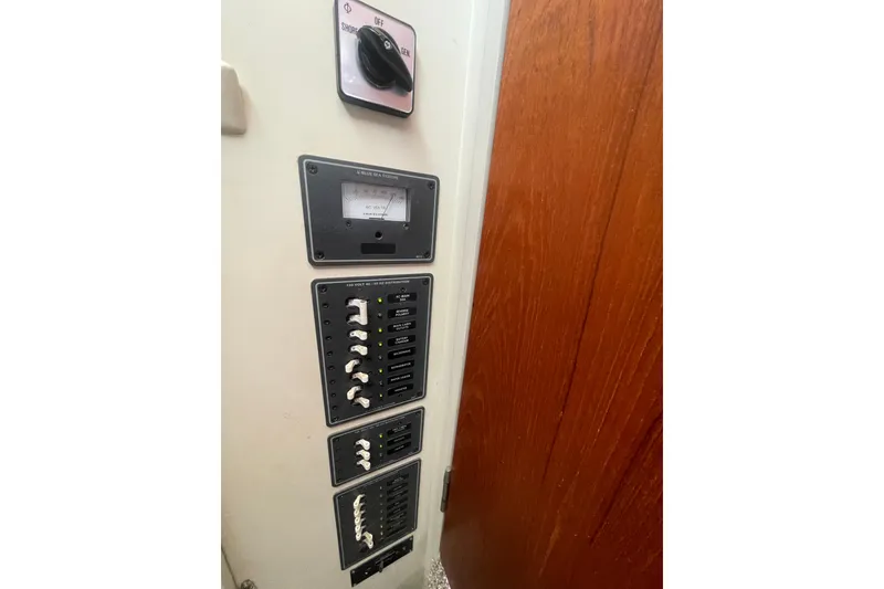 Slide: The Image of Electrical panel on a 1974 Tollycraft 37 Sedan boat, featuring switches and a voltage meter. - 44