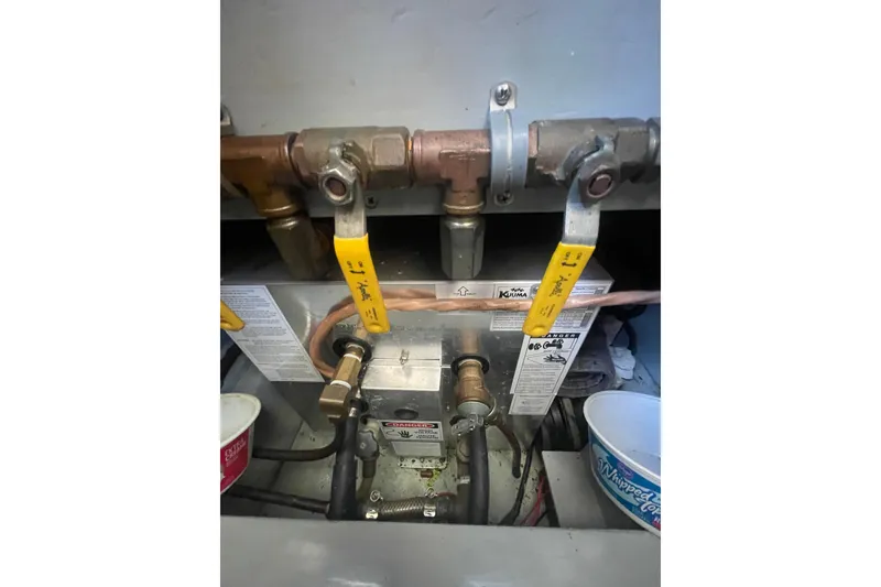 Slide: The Image of Engine room plumbing of a 1974 Tollycraft 37 Sedan boat, featuring valves and pipes. - 47