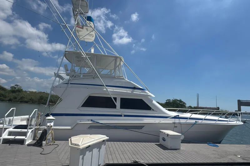 The Image of 1997 Bertram 54 Convertible yacht docked under a clear blue sky. - 0