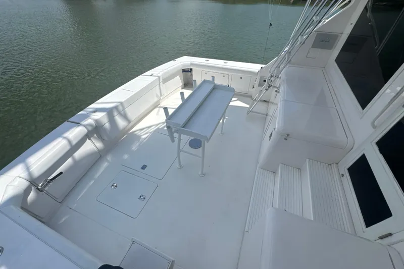 Slide: The Image of Spacious deck of a 1997 Bertram 54 Convertible yacht, featuring seating and fishing amenities. - 10