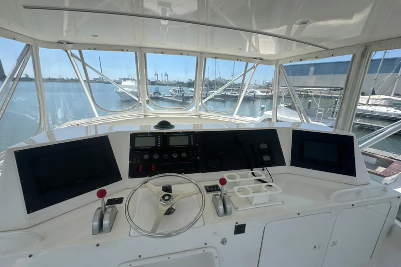 Slide: The Image of Cockpit view of a 1997 Bertram 54 Convertible yacht, showcasing navigation controls and marina backdrop. - 12