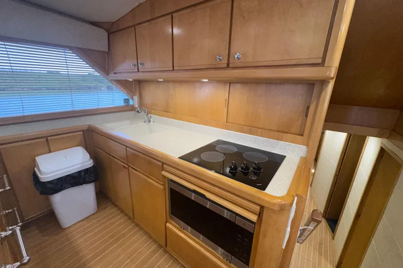 Slide: The Image of Kitchen area of a 1997 Bertram 54 Convertible yacht with stove and microwave. - 19