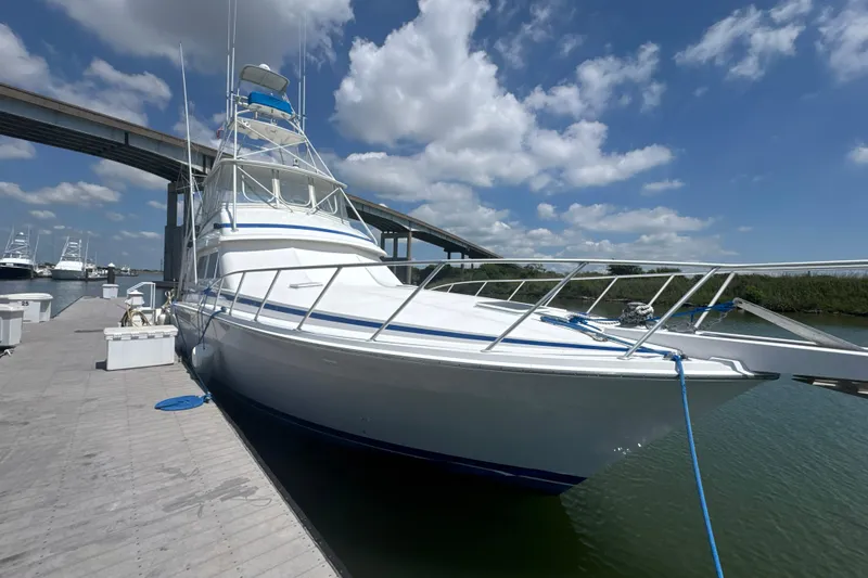 Slide: The Image of 1997 Bertram 54 Convertible yacht docked under a clear blue sky. - 2