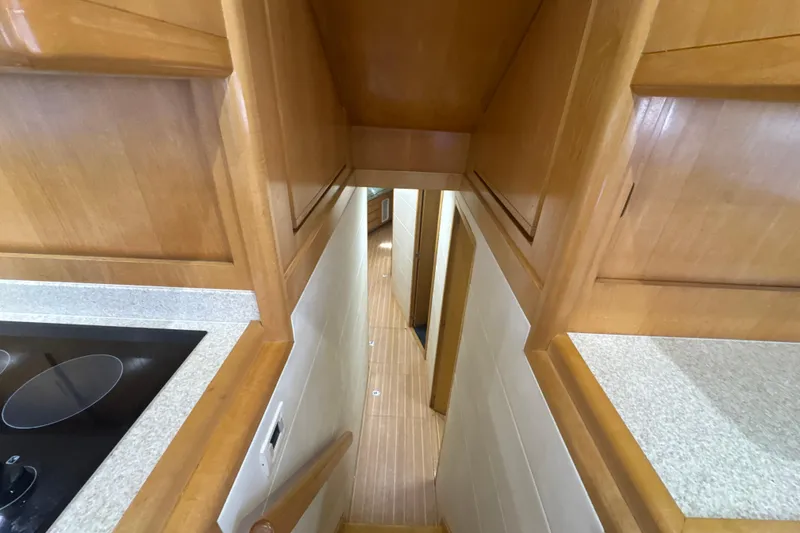 Slide: The Image of Interior view of 1997 Bertram 54 Convertible yacht, featuring wooden cabinetry and hallway. - 20