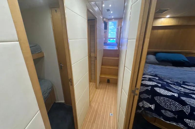 Slide: The Image of Interior of a 1997 Bertram 54 Convertible yacht with cozy bedrooms and wooden flooring. - 21