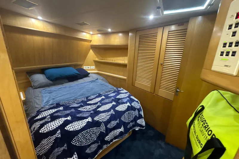 Slide: The Image of Cozy cabin interior of a 1997 Bertram 54 Convertible yacht with wooden accents and nautical bedding. - 22