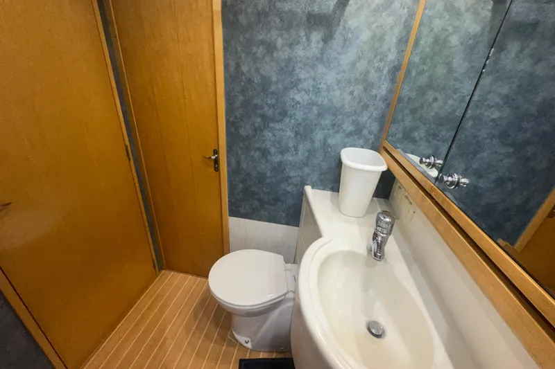 Slide: The Image of Bathroom interior of a 1997 Bertram 54 Convertible yacht, featuring a sink and toilet. - 26