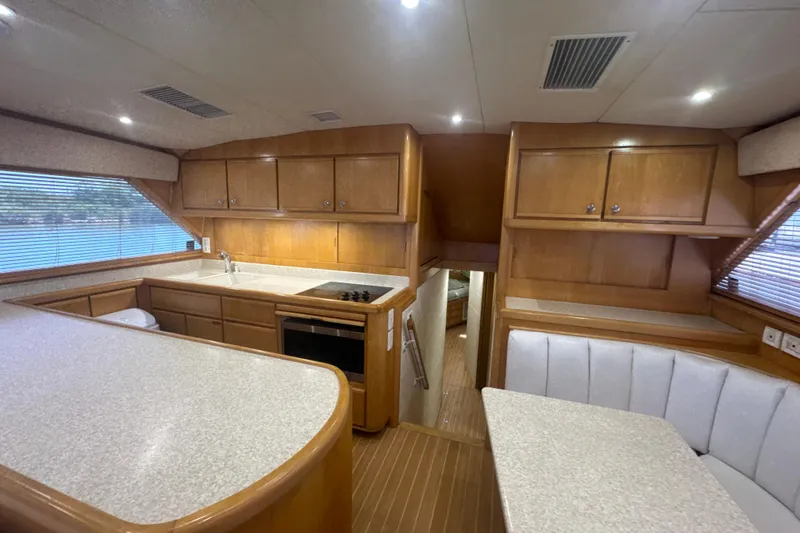 Slide: The Image of Interior of a 1997 Bertram 54 Convertible yacht with wood cabinetry and modern amenities. - 27