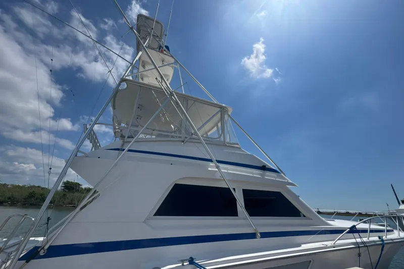 Slide: The Image of 1997 Bertram 54 Convertible yacht under clear blue sky, showcasing sleek design and structure. - 3