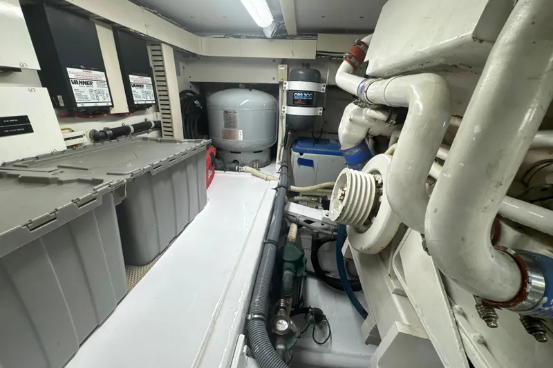 Slide: The Image of Engine room of a 1997 Bertram 54 Convertible yacht, featuring mechanical components and storage. - 33