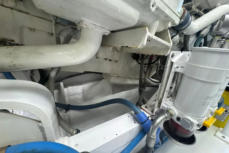 Slide: The Image of Engine room of a 1997 Bertram 54 Convertible yacht, showcasing pipes and machinery. - 34