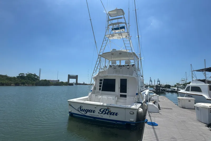 Slide: The Image of Bertram 54 Convertible 1997 yacht docked at marina under clear blue sky. - 4