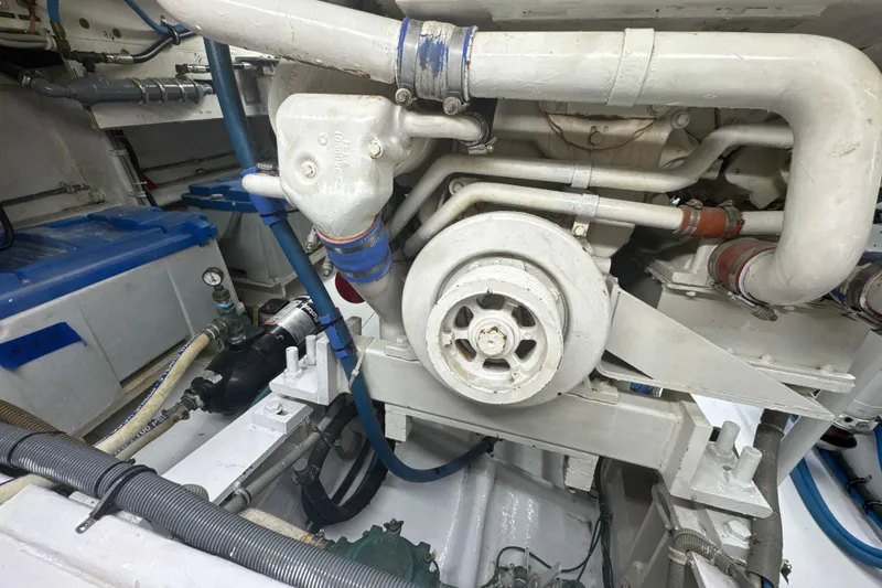 Slide: The Image of Engine room of a 1997 Bertram 54 Convertible yacht, showcasing mechanical components and piping. - 40