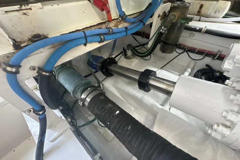 Slide: The Image of Engine compartment of a 1997 Bertram 54 Convertible boat, featuring hoses and mechanical components. - 43