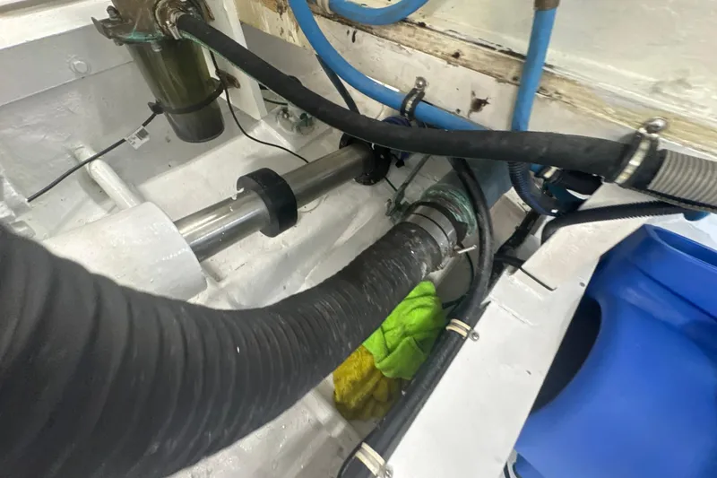 Slide: The Image of Engine room of a 1997 Bertram 54 Convertible boat, showing hoses and mechanical components. - 44