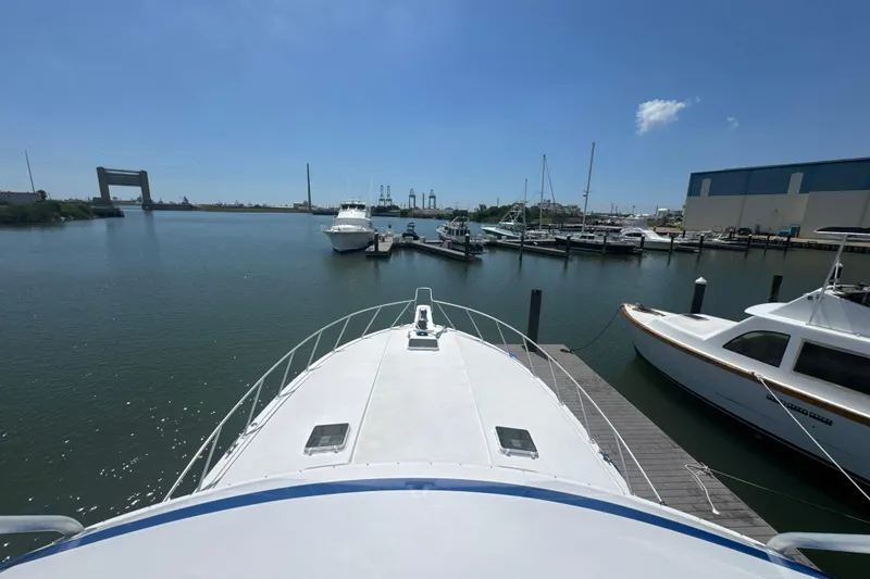 Slide: The Image of Bertram 54 Convertible 1997 yacht docked at marina under clear blue sky. - 6