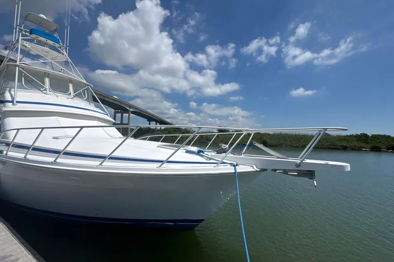 Slide: The Image of 1997 Bertram 54 Convertible yacht docked under a clear blue sky. - 8
