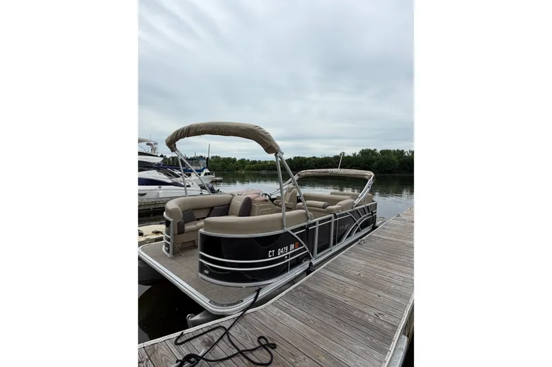 The Image of 2022 Sylvan Mirage 8522 Resorter pontoon boat docked on a calm lake. - 0