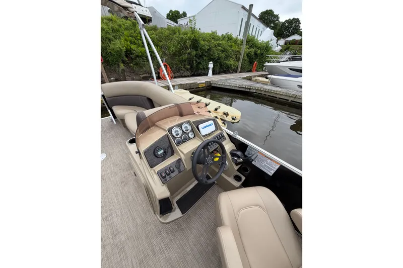 Slide: The Image of 2022 Sylvan Mirage 8522 Resorter boat interior with steering console and seating at dock. - 10