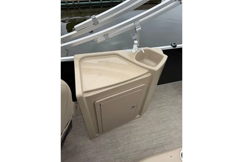 Slide: The Image of Interior view of 2022 Sylvan Mirage 8522 Resorter boat with a beige sink and storage compartment. - 12