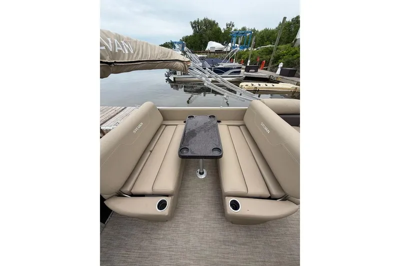 Slide: The Image of 2022 Sylvan Mirage 8522 Resorter pontoon boat with beige seating and table at dock. - 15