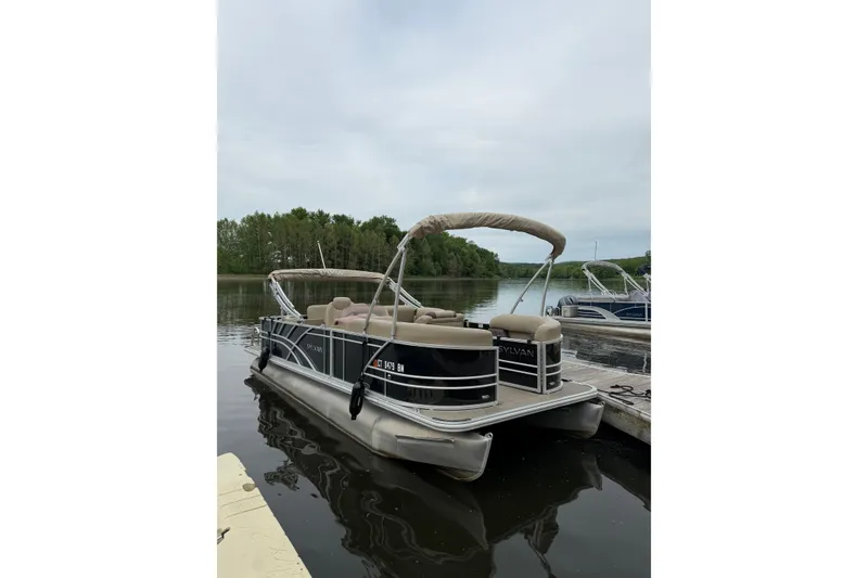 Slide: The Image of 2022 Sylvan Mirage 8522 Resorter pontoon boat docked on a calm lake. - 4