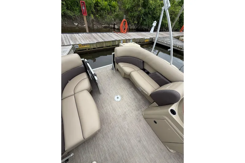 Slide: The Image of 2022 Sylvan Mirage 8522 Resorter pontoon boat interior with beige seating at dock. - 8