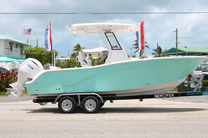 The Image of 2026 Sea Fox 228 Commander boat on trailer, turquoise hull, outdoor display. - 0