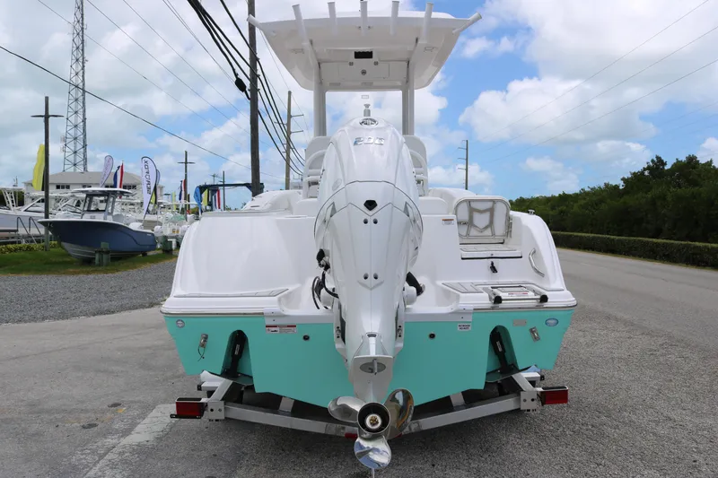 Slide: The Image of 2026 Sea Fox 228 Commander boat with outboard motor on trailer, parked roadside. - 5