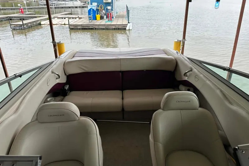 Slide: The Image of Interior of a 1998 Crownline 248 BR boat with beige seating at a dock. - 6