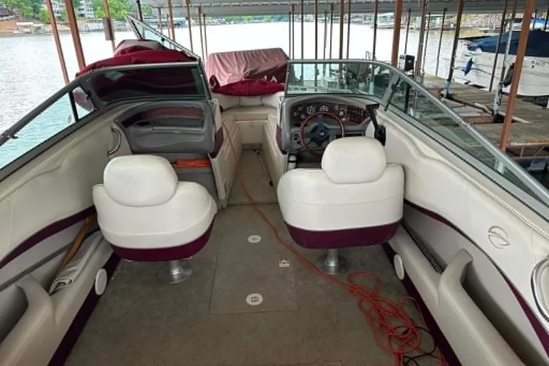 Slide: The Image of Interior of a 1998 Crownline 248 BR boat with white seating and dashboard view. - 9