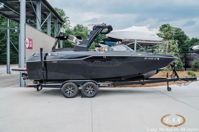 The Image of 2021 Malibu M240 boat on trailer at Lake Norman Marina, near gas dock. - 1