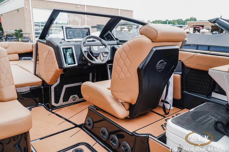 Slide: The Image of 2021 Malibu M240 boat interior with luxurious tan seating and advanced dashboard controls. - 14