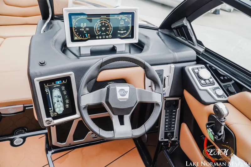 Slide: The Image of 2021 Malibu M240 boat dashboard with advanced digital controls and steering wheel. - 17