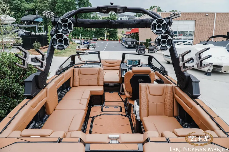 Slide: The Image of Luxurious 2021 Malibu M240 boat interior with tan leather seating and advanced audio system. - 8