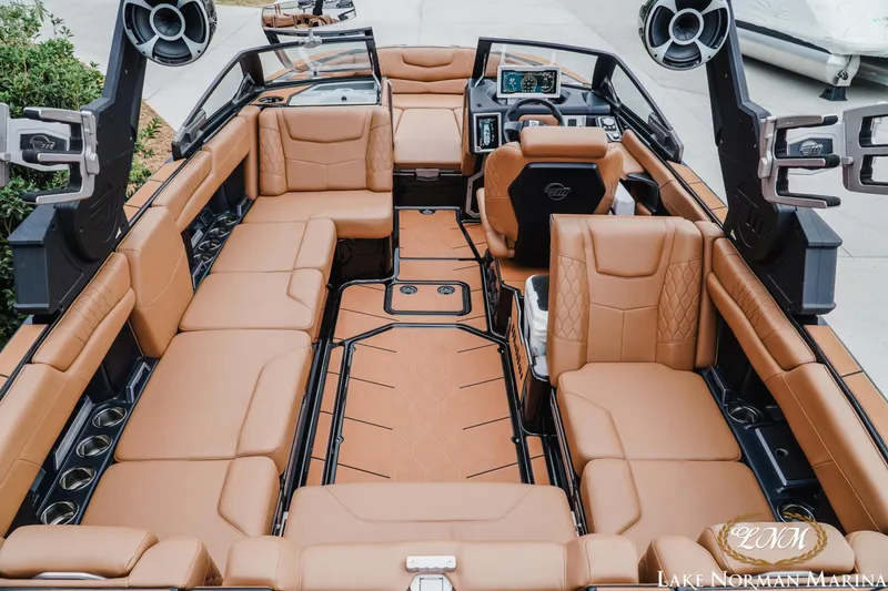 Slide: The Image of 2021 Malibu M240 boat interior with luxurious tan seating and advanced dashboard features. - 9