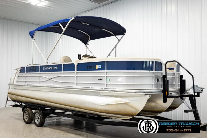 Slide: The Image of 2019 Berkshire 24 SB2 CTS pontoon boat with blue canopy on trailer in indoor storage. - 3