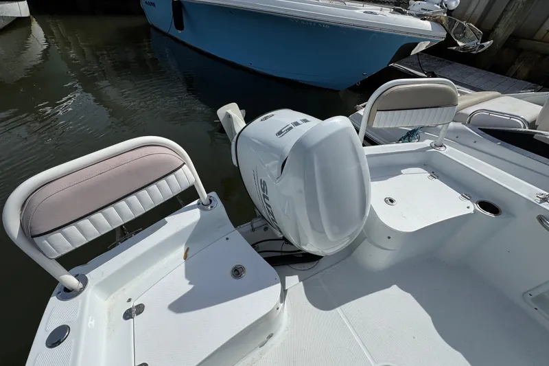 Slide: The Image of 2022 Barracuda 188 CCR boat with outboard motor and seating, docked on calm water. - 3