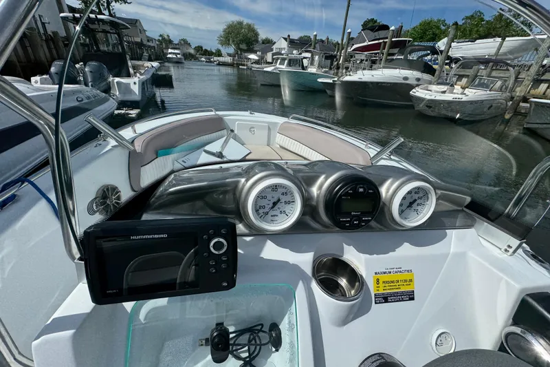 Slide: The Image of 2022 Barracuda 188 CCR boat dashboard with gauges and navigation system in a marina. - 7