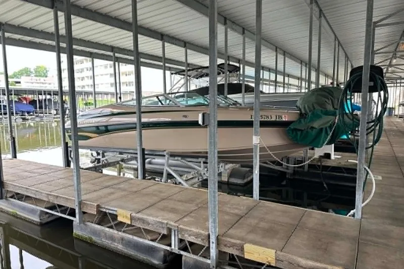 The Image of 1997 Crownline 225 BR boat docked in a covered marina. - 0