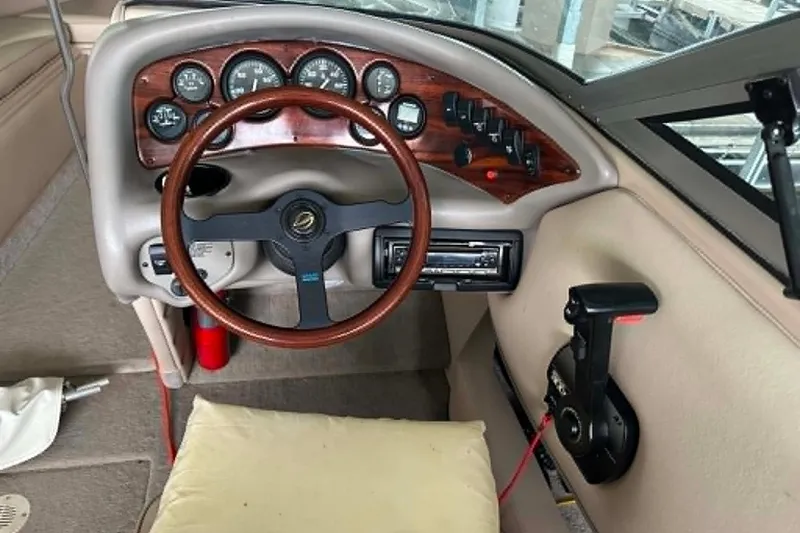 Slide: The Image of 1997 Crownline 225 BR boat dashboard with wood accents and steering wheel. - 12
