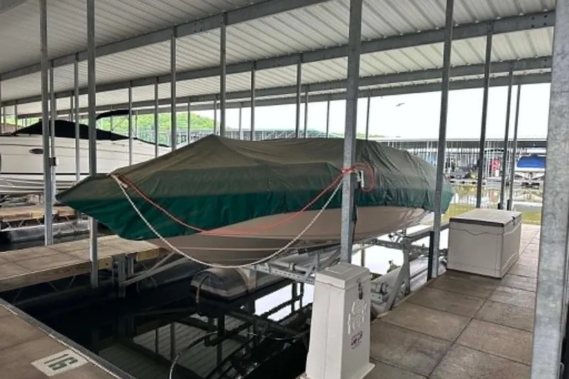 Slide: The Image of Covered 1997 Crownline 225 BR boat docked in a marina under a shelter. - 3