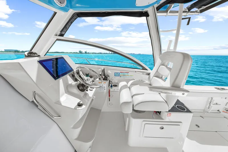 Slide: The Image of The cockpit of the 2027 Boston Whaler 285 Conquest features modern controls and comfortable seating. - 32