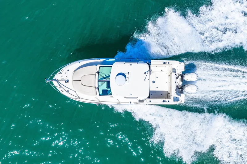 Slide: The Image of Aerial view of a Boston Whaler 285 Conquest on the water, featuring twin outboard engines and splashing wake. - 4