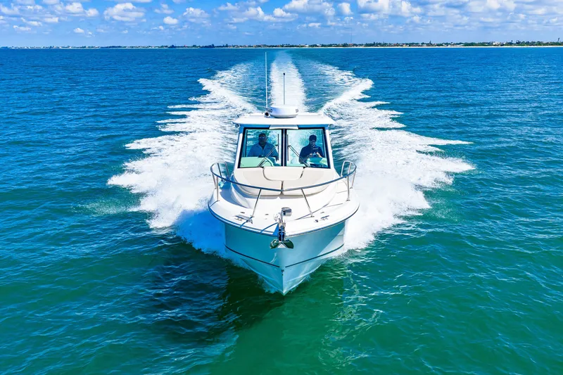 Slide: The Image of A 2027 Boston Whaler 285 Conquest speeds across the blue sea, leaving a white wake. - 2
